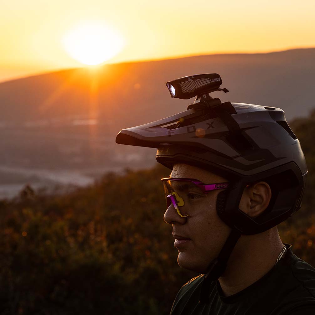mountain bike rider at sunset using niterider lights with helmet mounted headlight